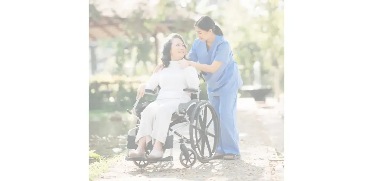 Caregiver assisting a senior client outdoors in a wheelchair