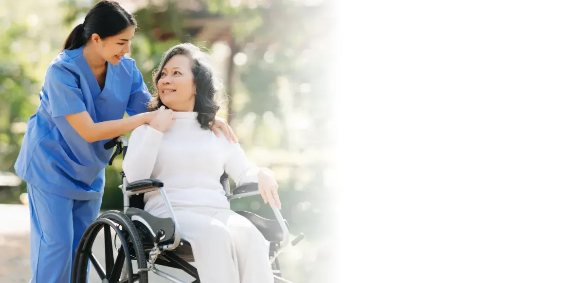 Caregiver supporting a senior client with mobility outdoors