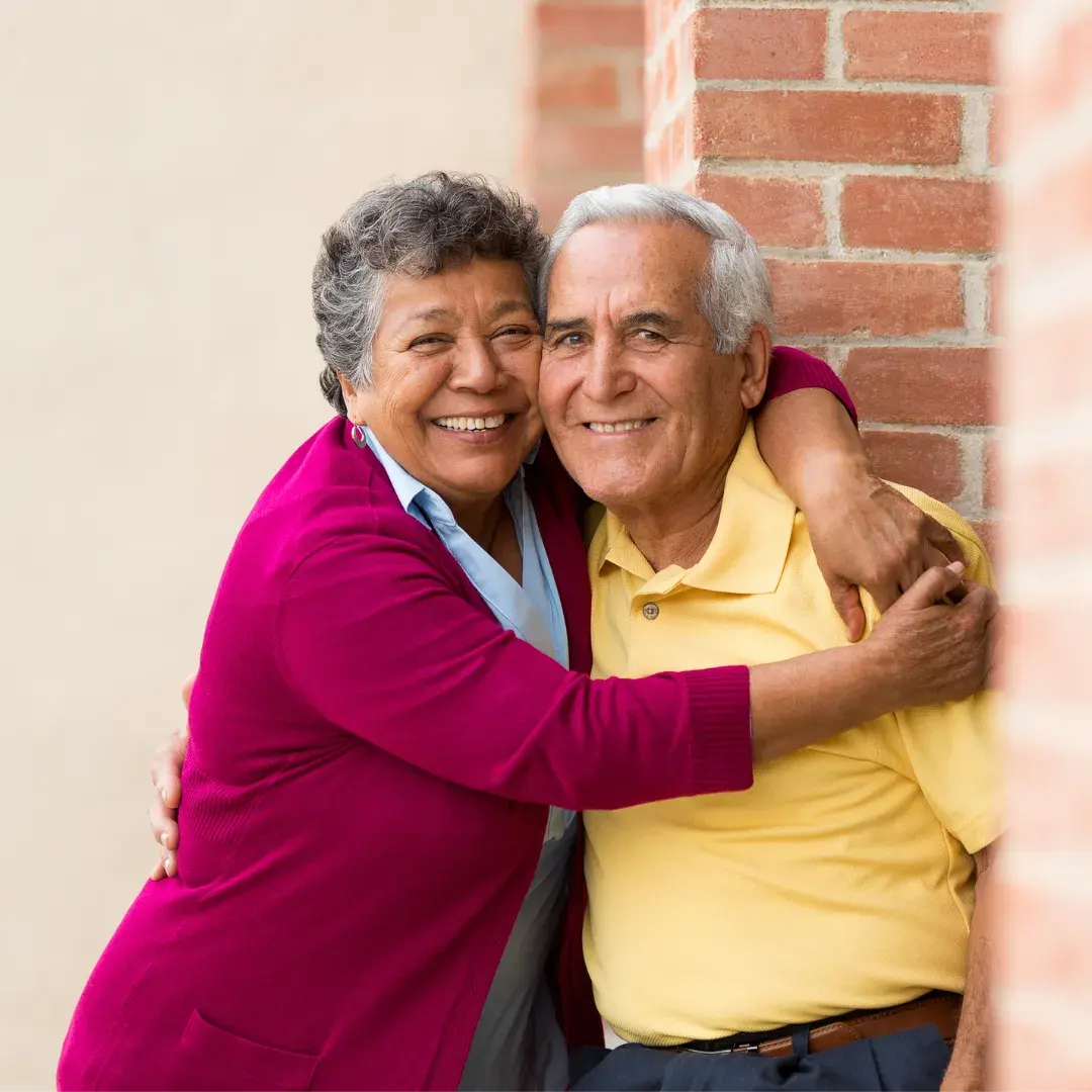 Happy senior couple embracing at home