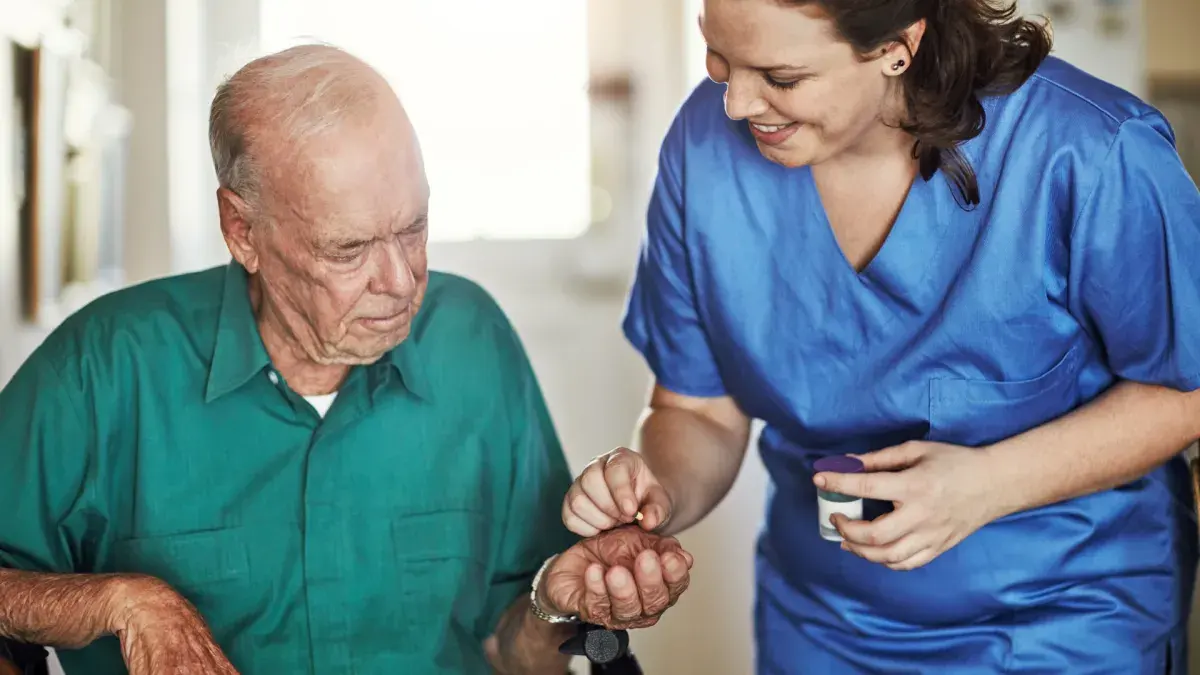 Caregiver helping a client manage medication
